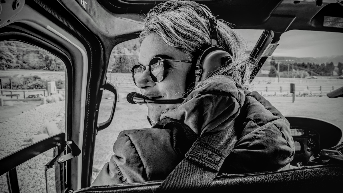 Alice sitting in the front seat of a helicopter