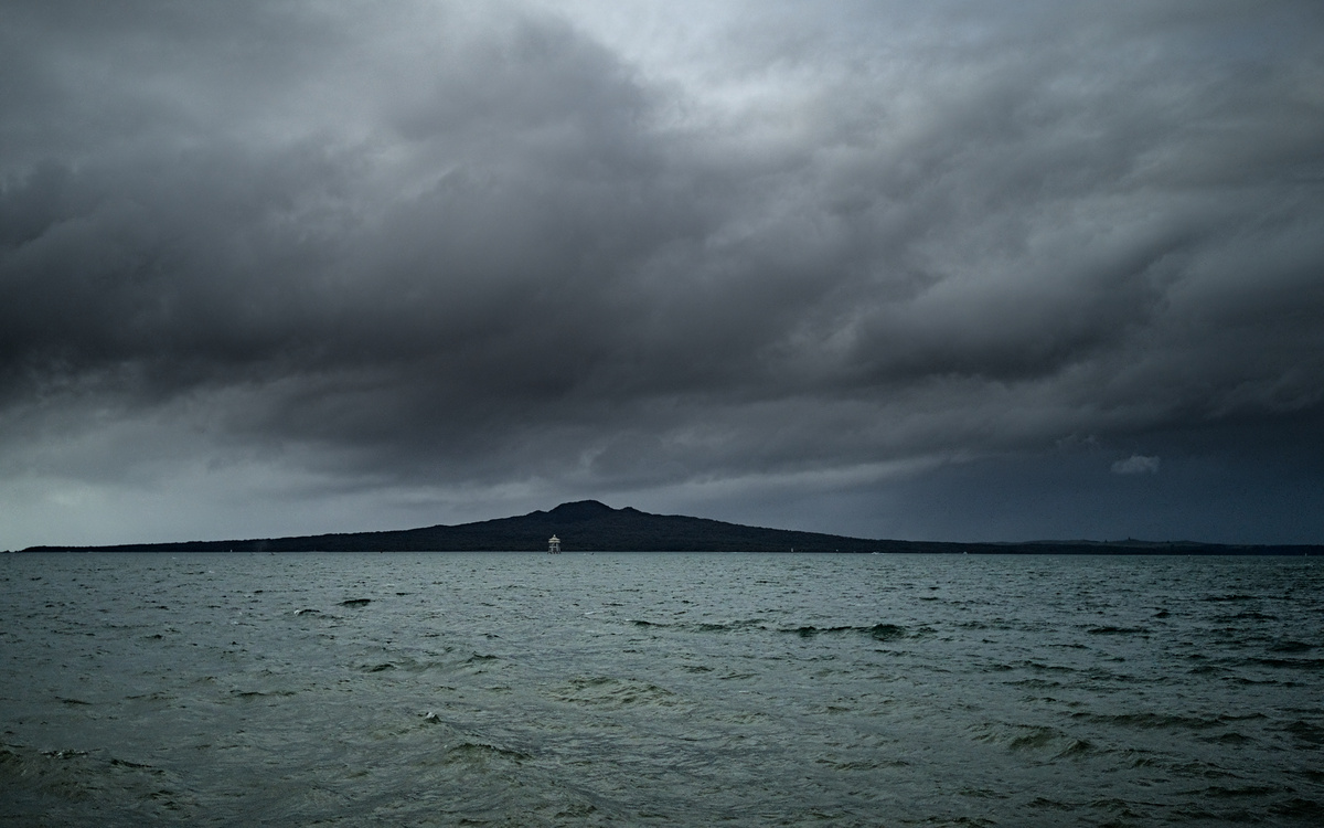 Rangitoto Island on a cloudy day with Bean Rock Lighthouse in the front